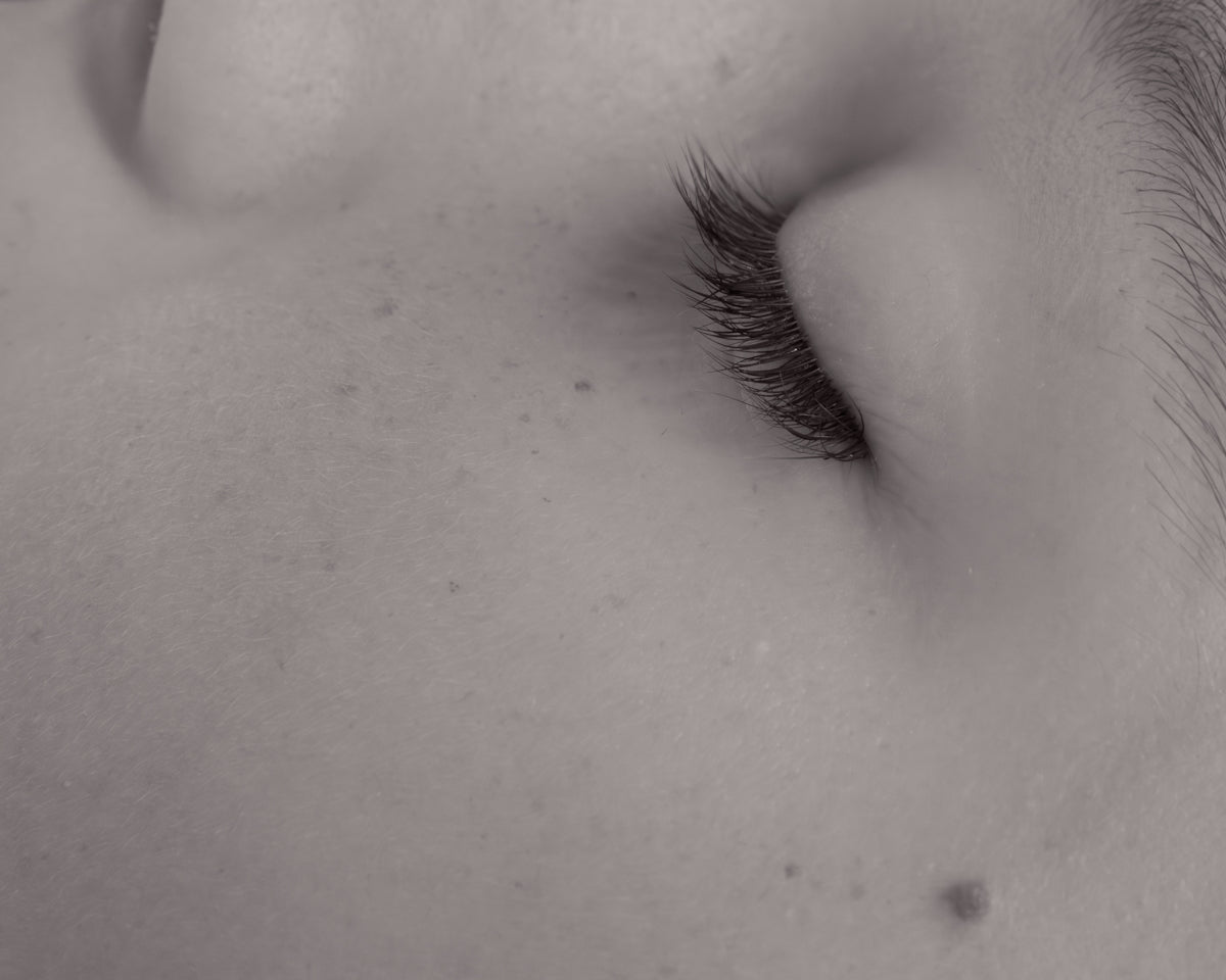 Close-up of a sleeping baby's closed eye and eyelashes.