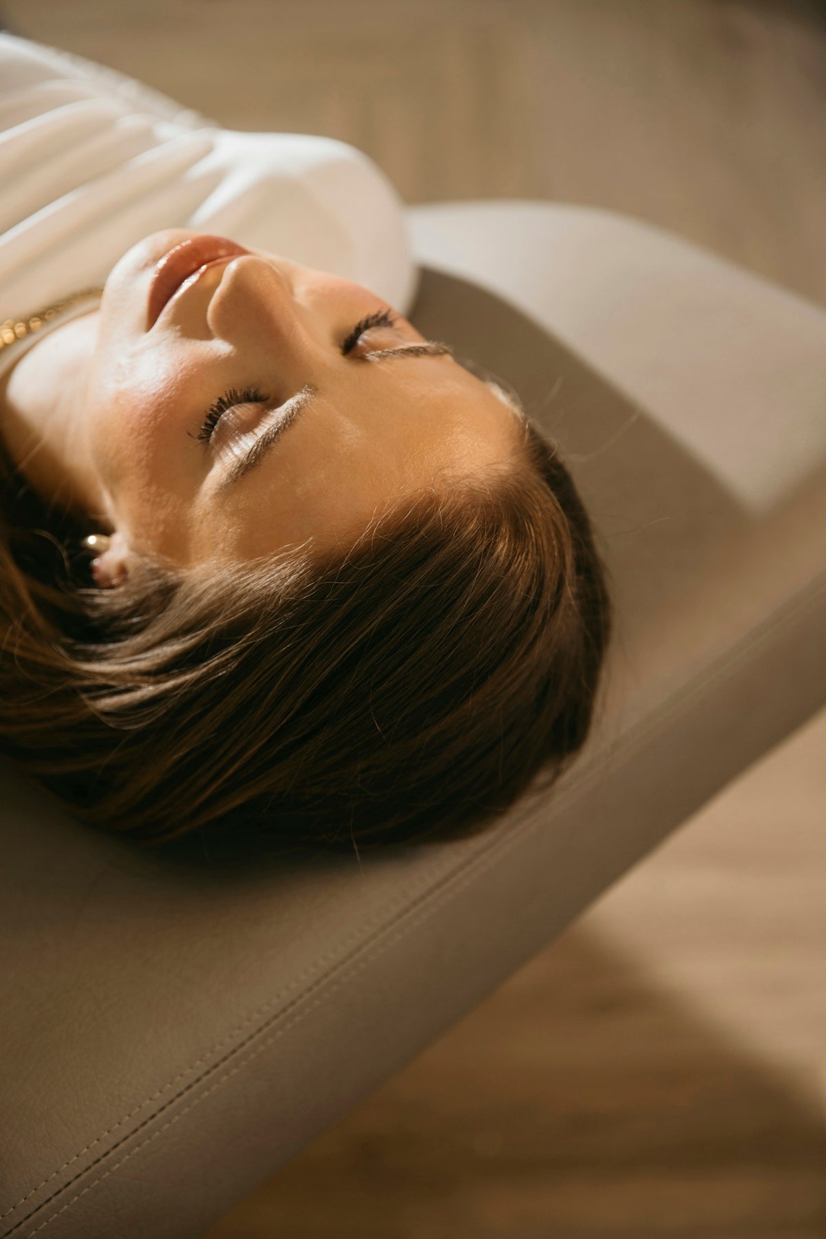 a woman laying on a couch with her eyes closed